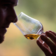 Man sniffs snifter of Scotch whisky.